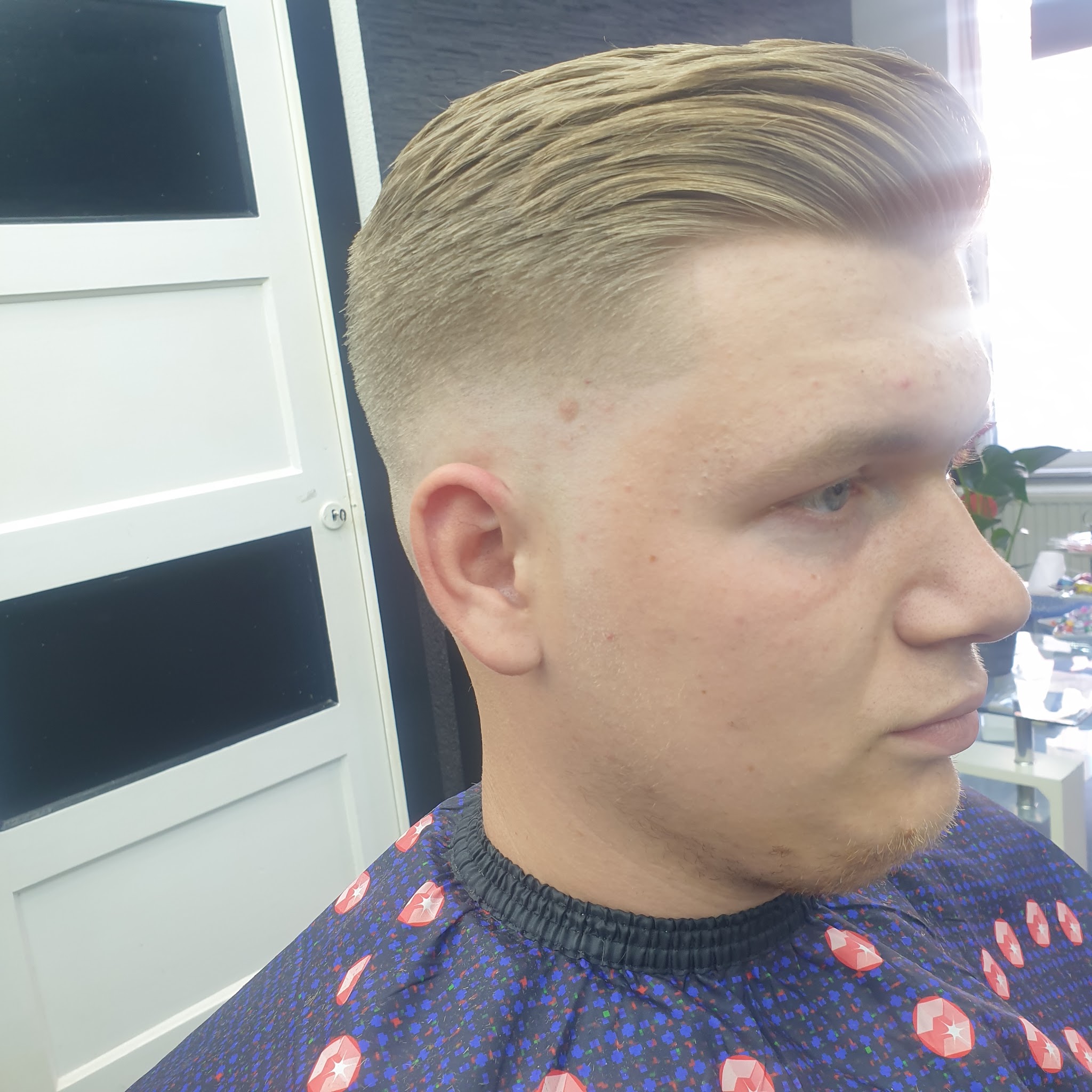 Afgewerkt kapsel met korte zijkanten en naar achteren gestyled haar bij MONO