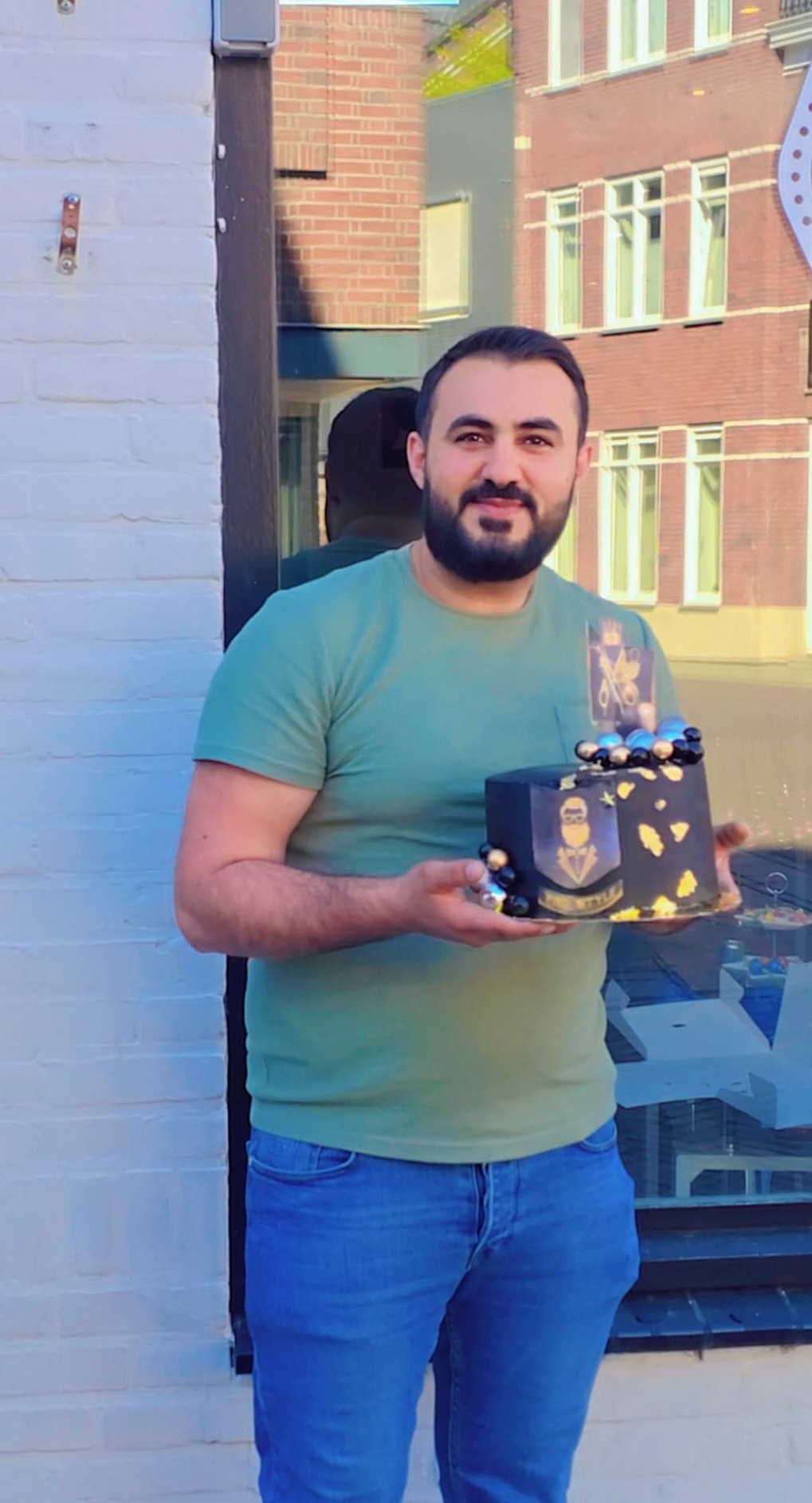 Portret voor de barbershop, met een feestelijke taart in de hand